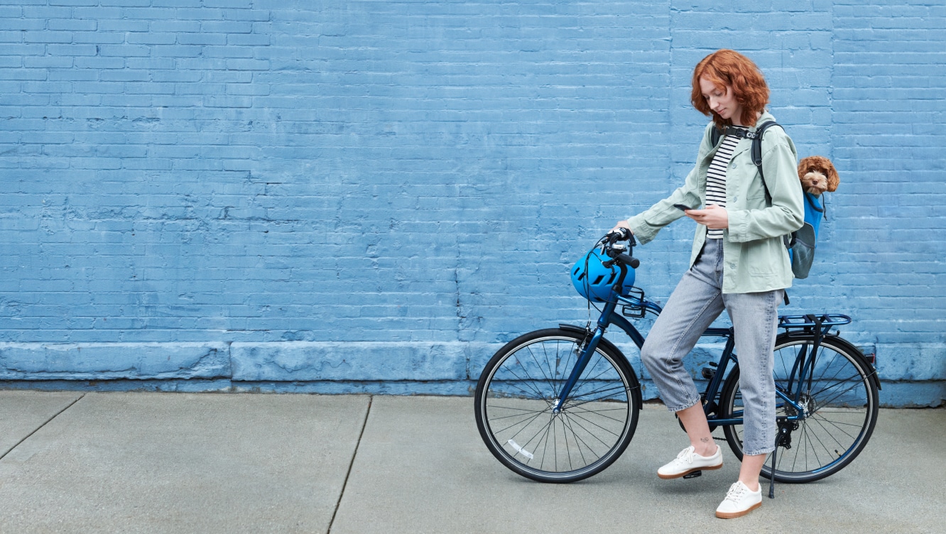 Women on a bike using the ADT+ app on her phone